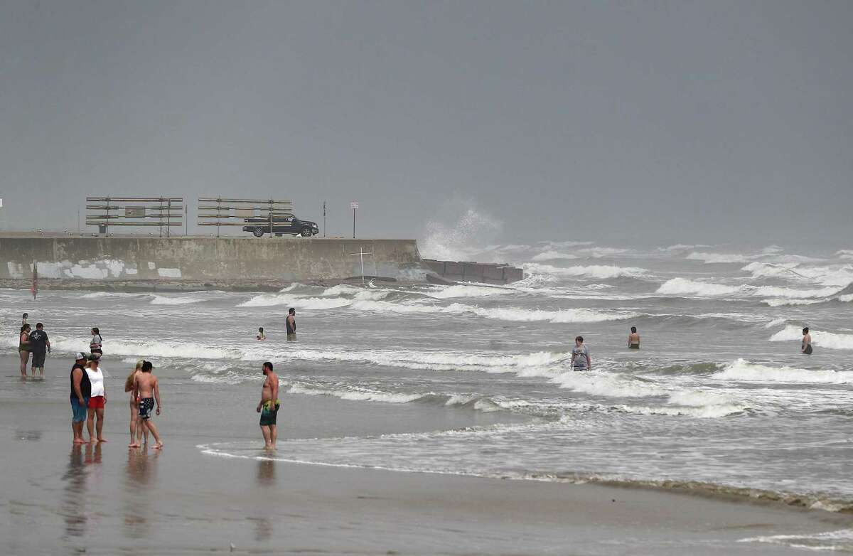 Swimmers enjoy the waves near the West End Seawall in Galveston on April 13, 2022, an area experts say would be impacted by the “Ike Dike” plan.