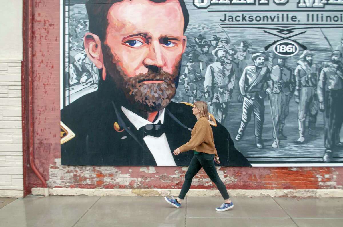 Jess Gale of Jacksonville walks past a mural of Ulysses S. Grant on East State Street that commemorates his troops' 1861 march through Jacksonville. Last week marked the 200th anniversary of the birth of the Civil War general and two-term president, and his legacy isn't getting any less complicated. 