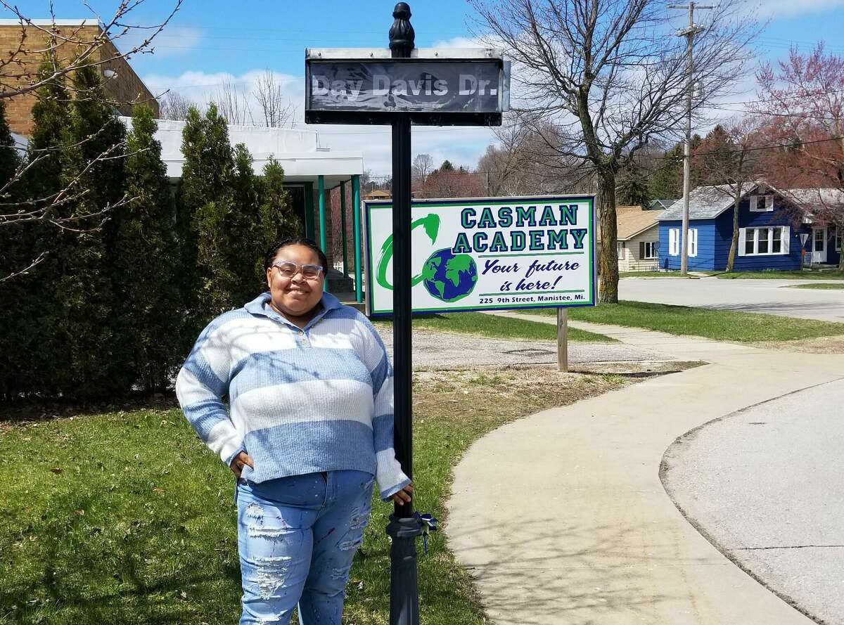 Day Davis, the CASMAN Academy Student of the Month, poses next to the sign that names the school driveway in her honor.