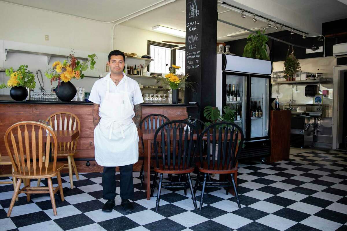 店主安德烈斯·吉拉尔多·弗洛雷斯站在奥克兰特梅斯卡尔区的蜗牛酒吧里。