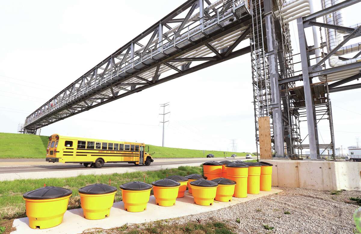 A school bus passes under the new pipeline bridge across Route 3 in Hartford Monday. The bridge carries at least 8 pipelines above the highway.