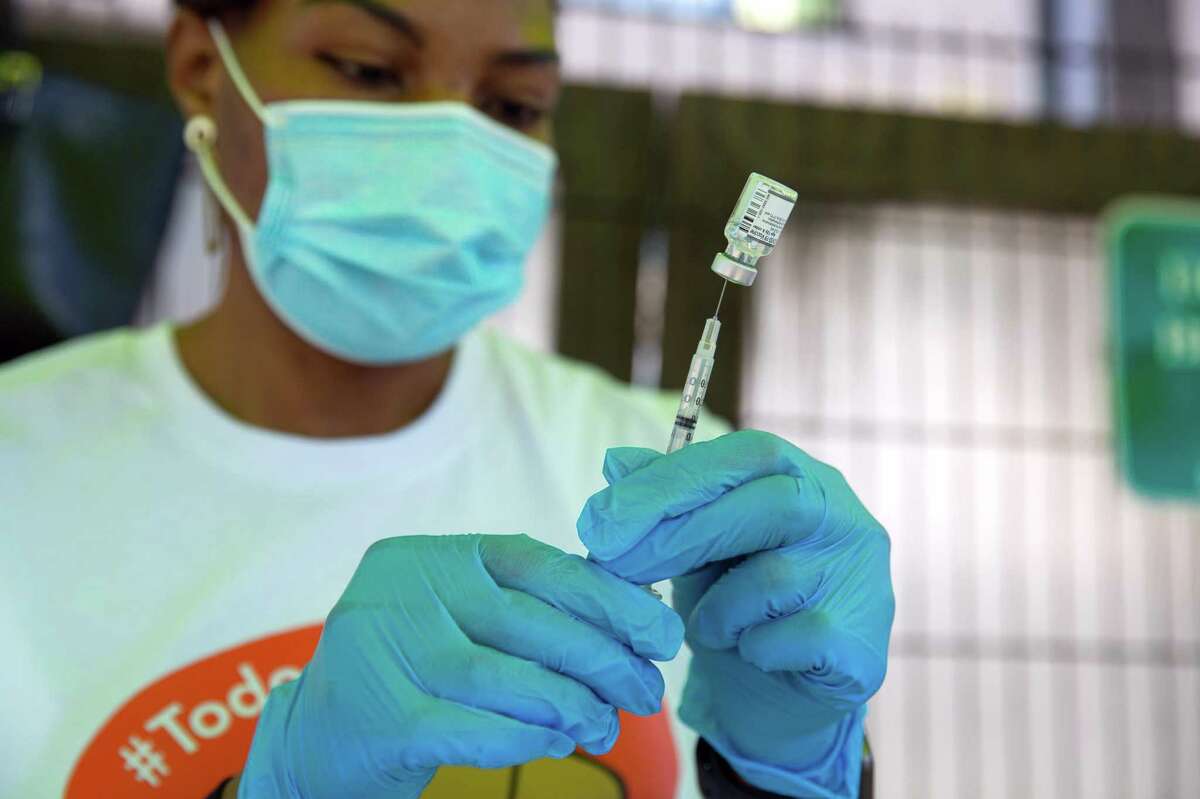 Judith Ngieh, registered nurse, prepares COVID vaccine, during the “Vidas Saludables” Community Health and Wealth Fair hosted by the Mission Economic Development Agency in Chan Kaajal Park in San Francisco, Calif.