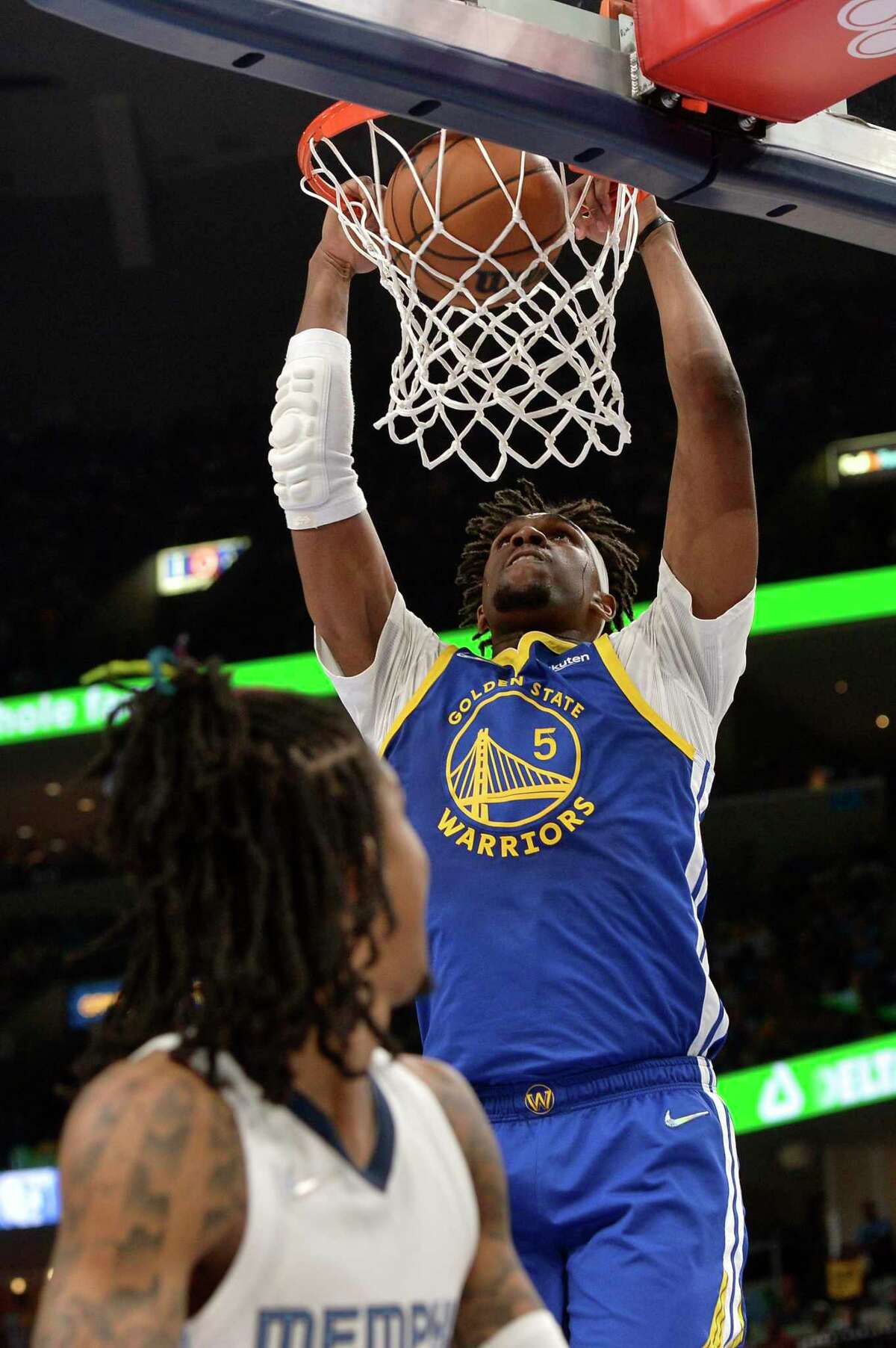 Golden State Warriors center Kevon Looney (5) dunks over Memphis Grizzlies guard Ja Morant in the second half during Game 1 of a second-round NBA basketball playoff series Sunday, May 1, 2022, in Memphis, Tenn. (AP Photo/Brandon Dill)