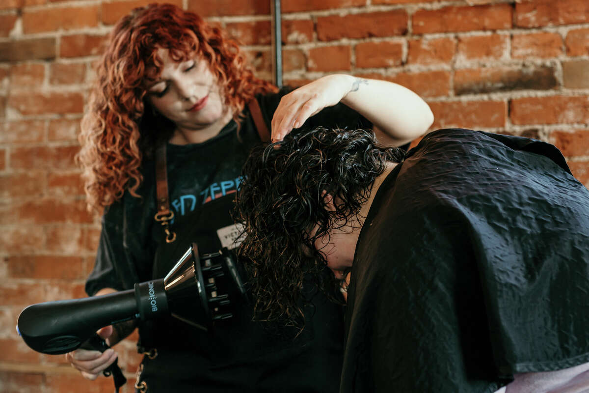 Master Stylist Heather Pearson, manager of VSalon By Valerie, a full-service salon and blow dry lounge, blow dries a client's hair at the new salon, 102 W. 7th St., in Alton.