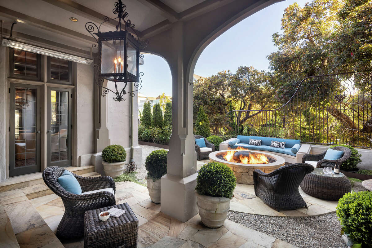 The outdoors are as luxe as the indoors, as evidenced by this patio and fire ring, surrounded by trees. 