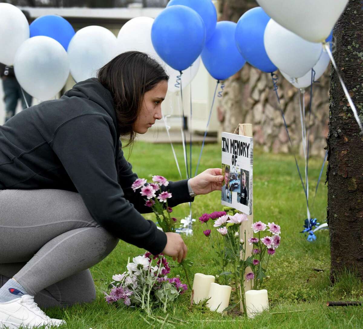 Kassidy Lopez, above, a close friend of Brandon Forlastro, places flowers near his photograph before a candle-lighting vigil Monday evening near 243 Danbury Road in New Milford. The vigil is to remember Brandon, who died in a motorcycle accident Sunday.