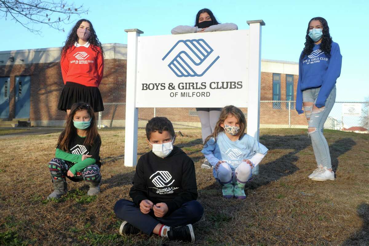 Seated front, Thomas Marder, kneeling left and right, Lucia Garcia and Mirella Soto, and standing left to right Lissette Soto, Alexis Broderick and Tiffany Ialeggio pose in front of Milford Boys & Girls Clubs, in Milford, Conn. Dec. 3, 2020.