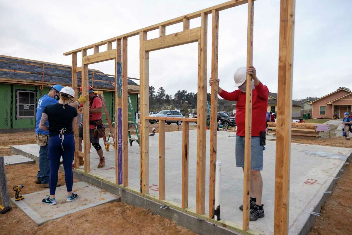 Volunteers place and secure the walls to a home for Deanna Fallin during a home building reveal hosted by Habitat for Humanity of Montgomery County, Saturday, March 13, 2021, in the Cedar Creek Community of Conroe.