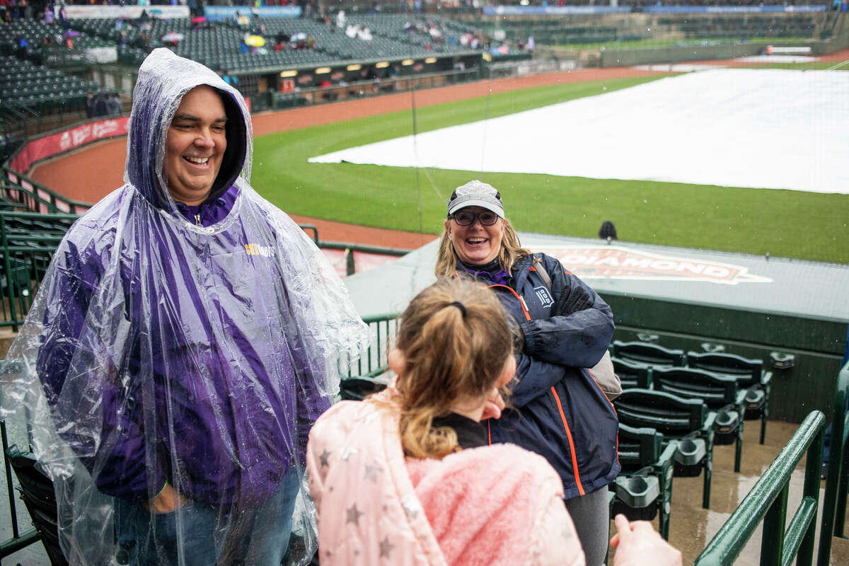 Caro Community Schools staff members Jeremy Ball, left, and Doreen Oedy, right, chat with a student during School Kids Day presented by Central Michigan University Tuesday, May 3, 2022 at Dow Diamond in Midland. The Great Lakes Loons vs. Beloit Sky Carp game was eventually canceled due to rain.