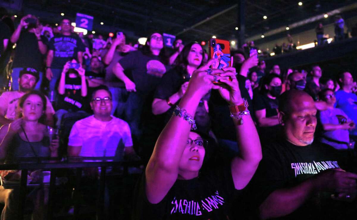 Fans cheer and take photos at the start of the Smashing Pumpkins concert on Monday.
