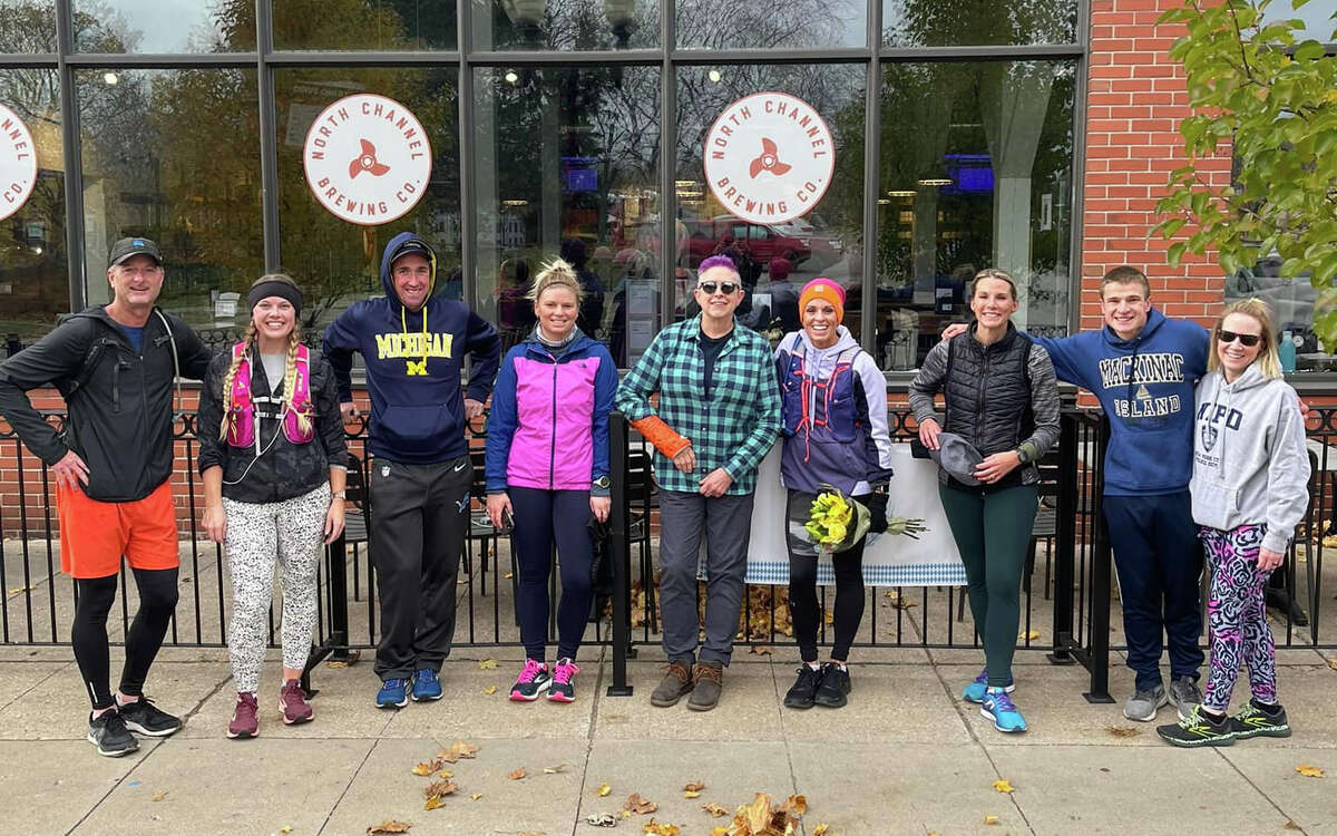 A group poses outside North Channel Brewing Co. before a group run.