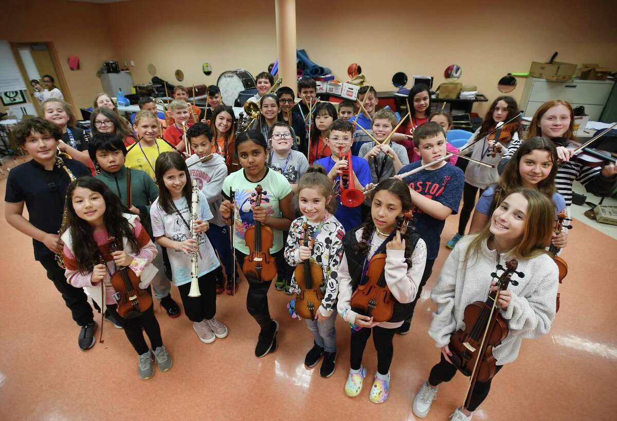 Perry Hill School students show off some of the dozens of new student instruments donated to the school system by Joe Shapiro, owner of Ansonia's recently closed Banko's Music store, at the school in Shelton, Conn., on Tuesday, May 3, 2022.