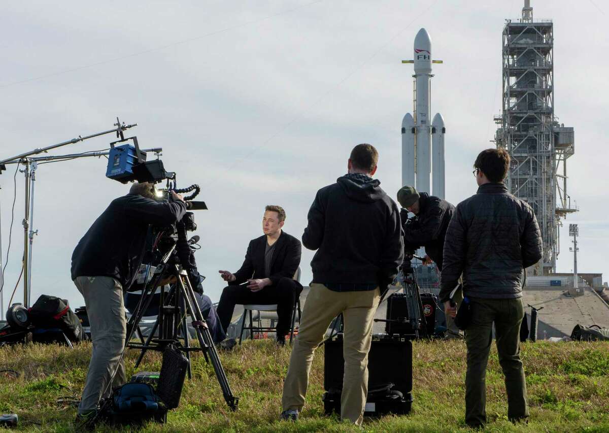 Elon Musk addresses the media in 2018 at NASA’s Kennedy Space Center in Cape Canaveral, Fla. Behind him is the SpaceX Falcon Heavy rocket.