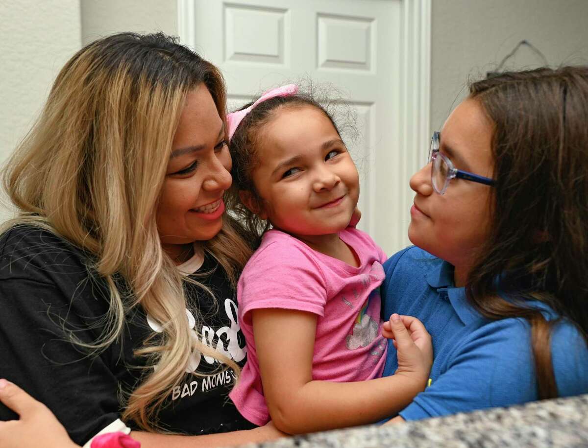 Christy Gonzalez, left, a member of the Facebook group Bad Moms of San Antonio, shares a moment with her children, Caroline, middle, and Litzy.