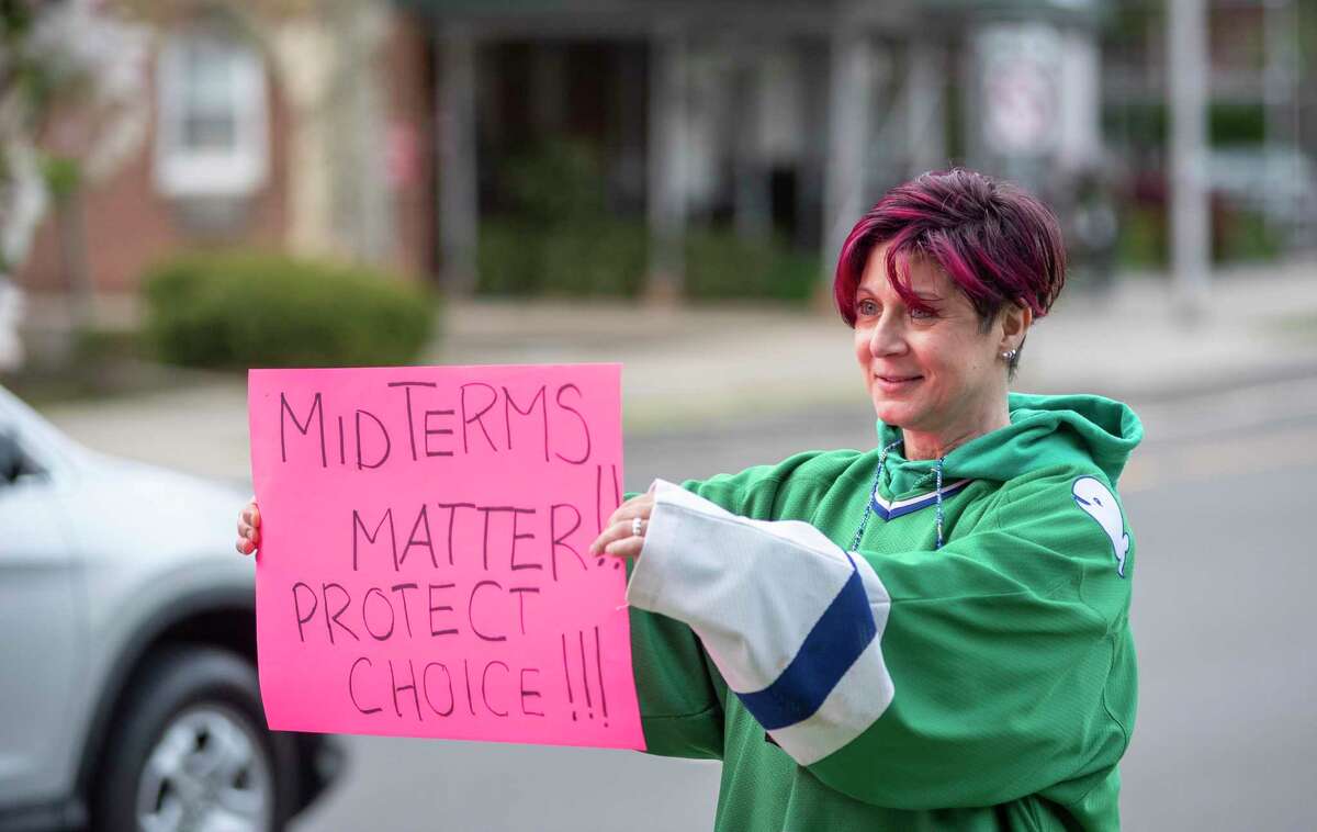 Rudi Karukas waves a “midterms matter” poster at a reproductive rights rally at Latham Park in Stamford on Tuesday, May 3, 2022.