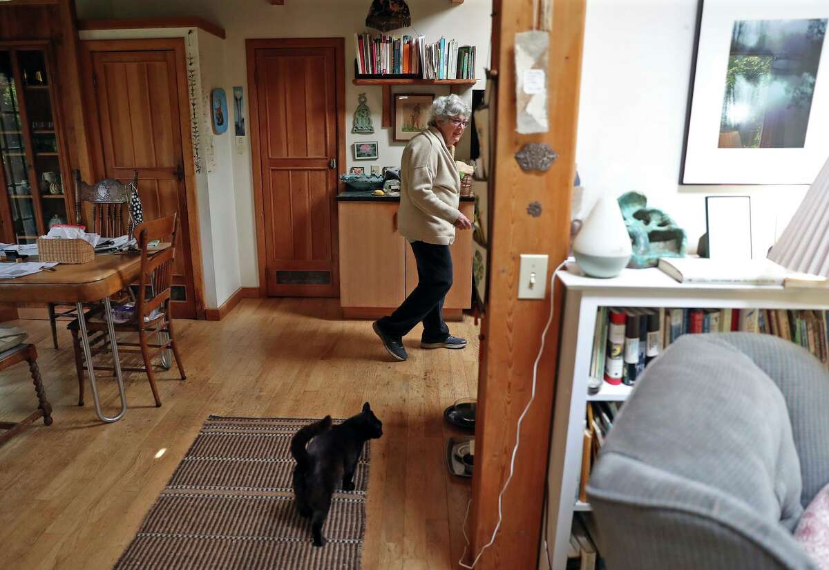 Bobbi Loeb and her cat, Critter, at home in Point Reyes. Loeb is a retired preschool teacher and worries about other local workers being priced out of the coastal town or taking on long commutes due to unaffordable housing.