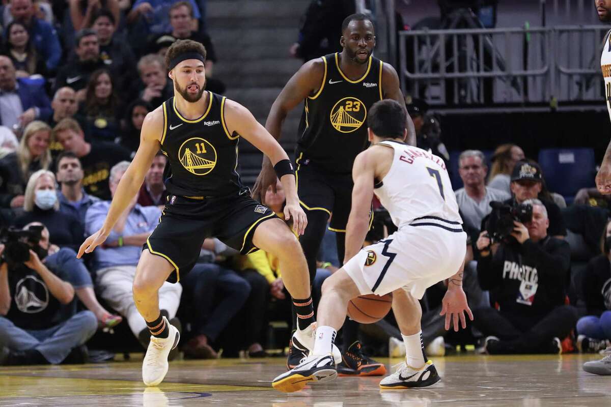 Golden State Warriors’ Klay Thompson and Draymond Green defend against Denver Nuggets’ Facundo Campazzo during Game 5 of NBA Western Conference First Round playoff game at Chase Center in San Francisco, Calif, on Wednesday, April 27, 2022.