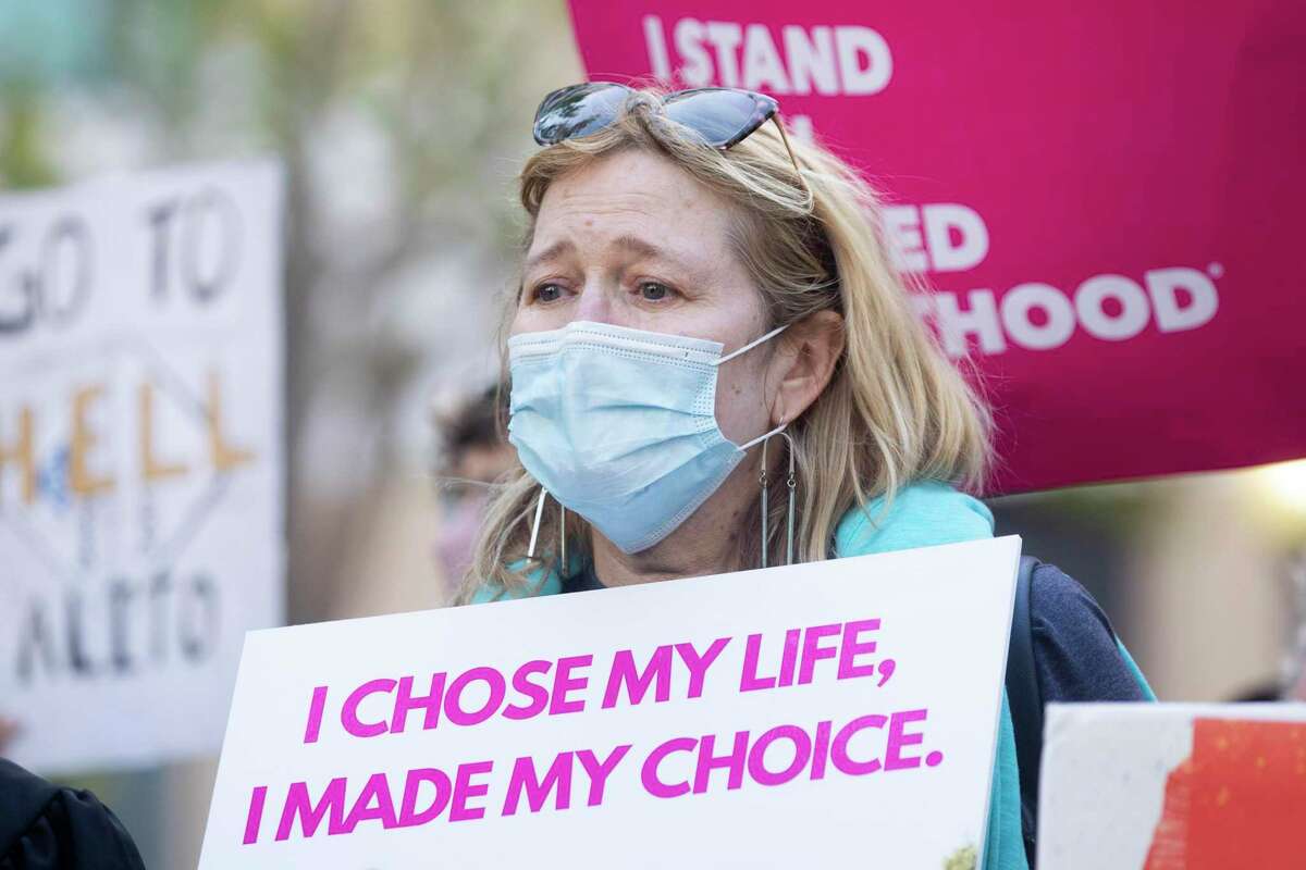 Martha Kreeger is overcome with emotion while standing alongside abortion activists and supporters during a protest outside of the Ronald V. Dellums Federal Building in Oakland, Calif. Tuesday, May 3, 2022 in response to the leak of a draft opinion on a potential Supreme Court vote to overturn Roe v. Wade.