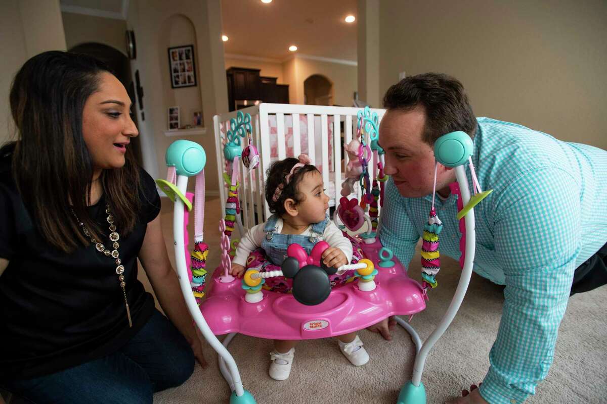 Archana and Anthony Acosta play with their baby in their home Sunday, March 6, 2022, in Rosharon, Texas.