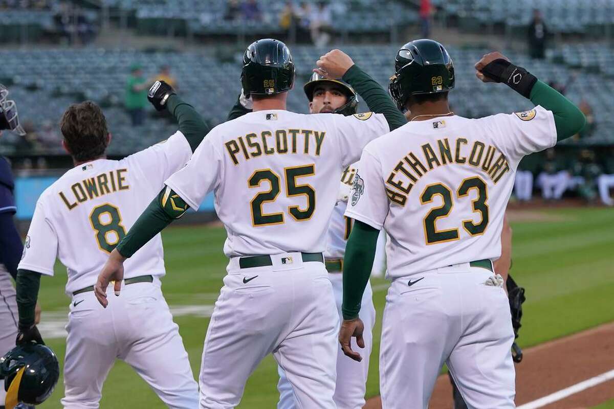Oakland Athletics' Kevin Smith, facing, celebrates after hitting a grand slam that scored Jed Lowrie (8), Stephen Piscotty (25) and Christian Bethancourt (23) during the first inning of the team's baseball game against the Tampa Bay Rays in Oakland, Calif., Tuesday, May 3, 2022. (AP Photo/Jeff Chiu)