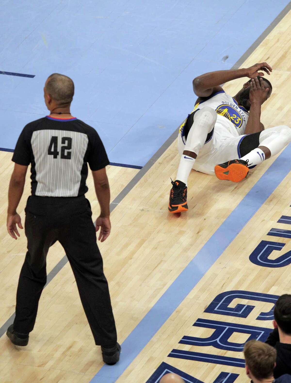 Draymond Green (23) lies on the floor after being hit in the eye In the first quarter as the Golden State Warriors played the Memphis Grizzlies in Game 2 of the second round of the NBA Playoffs at Fedex Forum in Memphis, Tenn., on Tuesday, May 3, 2022.