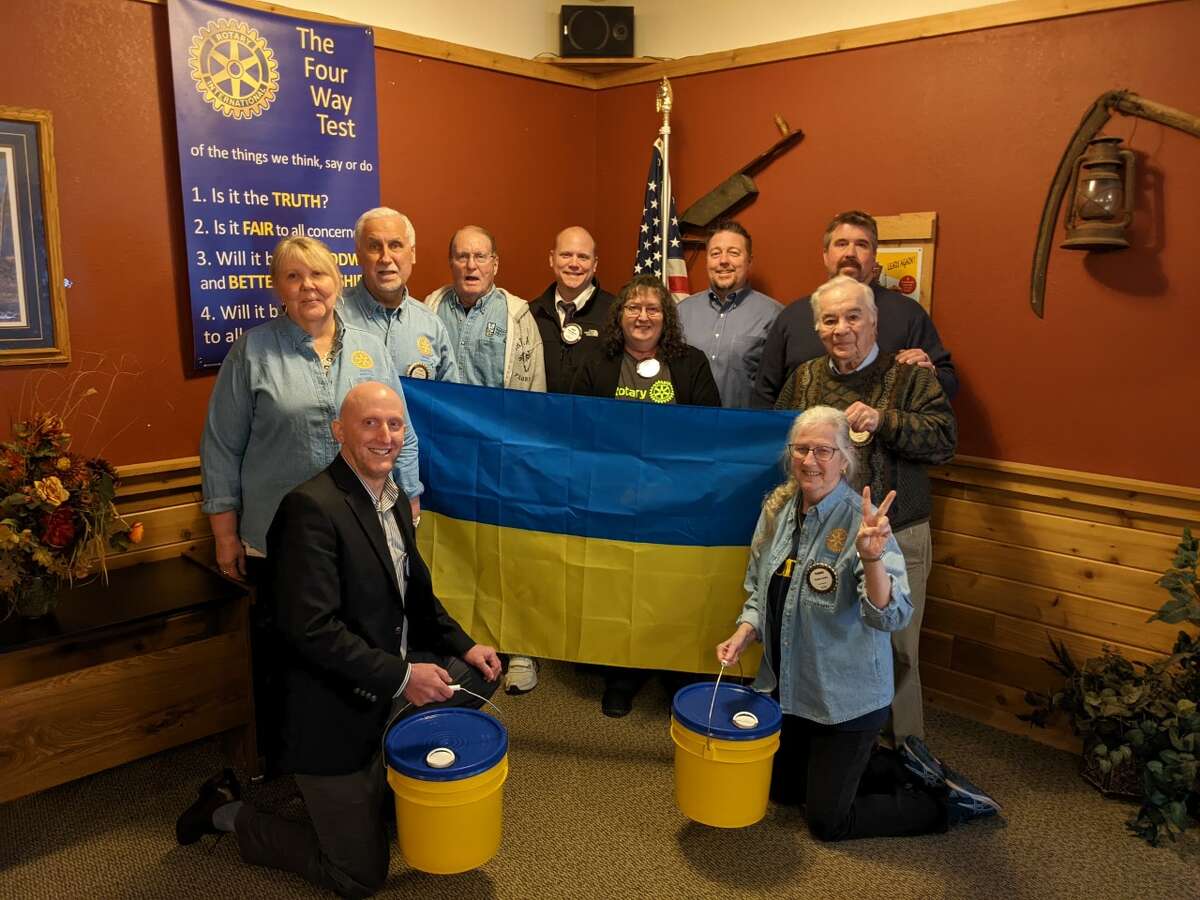 Ukraine Relief Effort: Local Rotary Club members donate into one of the group's collection barrels to kick-start Rotary International Ukraine Relief Fundraising Campaign here. The barrels' distinct blue and yellow colors are symbolic of the national flag. Rotarians are accepting public donations near Coles Insurance Agency and Wenger Insurance Agency in downtown Baldwin during Blessing Weekend, May 13-15. (Courtesy photo)