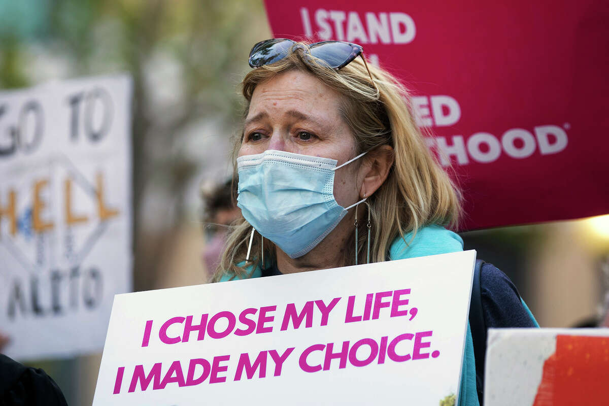 Martha Kreeger is overcome with emotion while standing alongside abortion rights activists and supporters during a protest outside of the Ronald V. Dellums Federal Building in Oakland, Calif., Tuesday, May 3, 2022, in response to the leak of a draft opinion on a potential Supreme Court vote to overturn Roe v. Wade. 