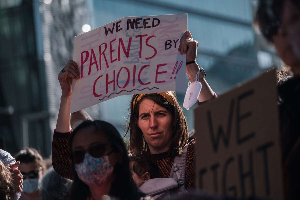 A person raises a sign reading "We Need Parents by Choice" as pro-abortion rights protesters gather in large numbers in front of the Phillip Burton Federal Building to defend abortion rights in San Francisco on May 3, 2022. 