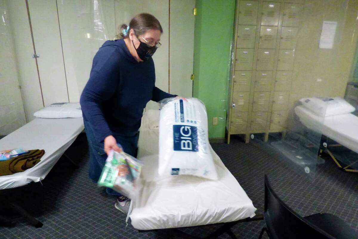 Lisa Clarke, family life service director at ECHO His Love, straightens a bed at the nonprofit's main campus. 
