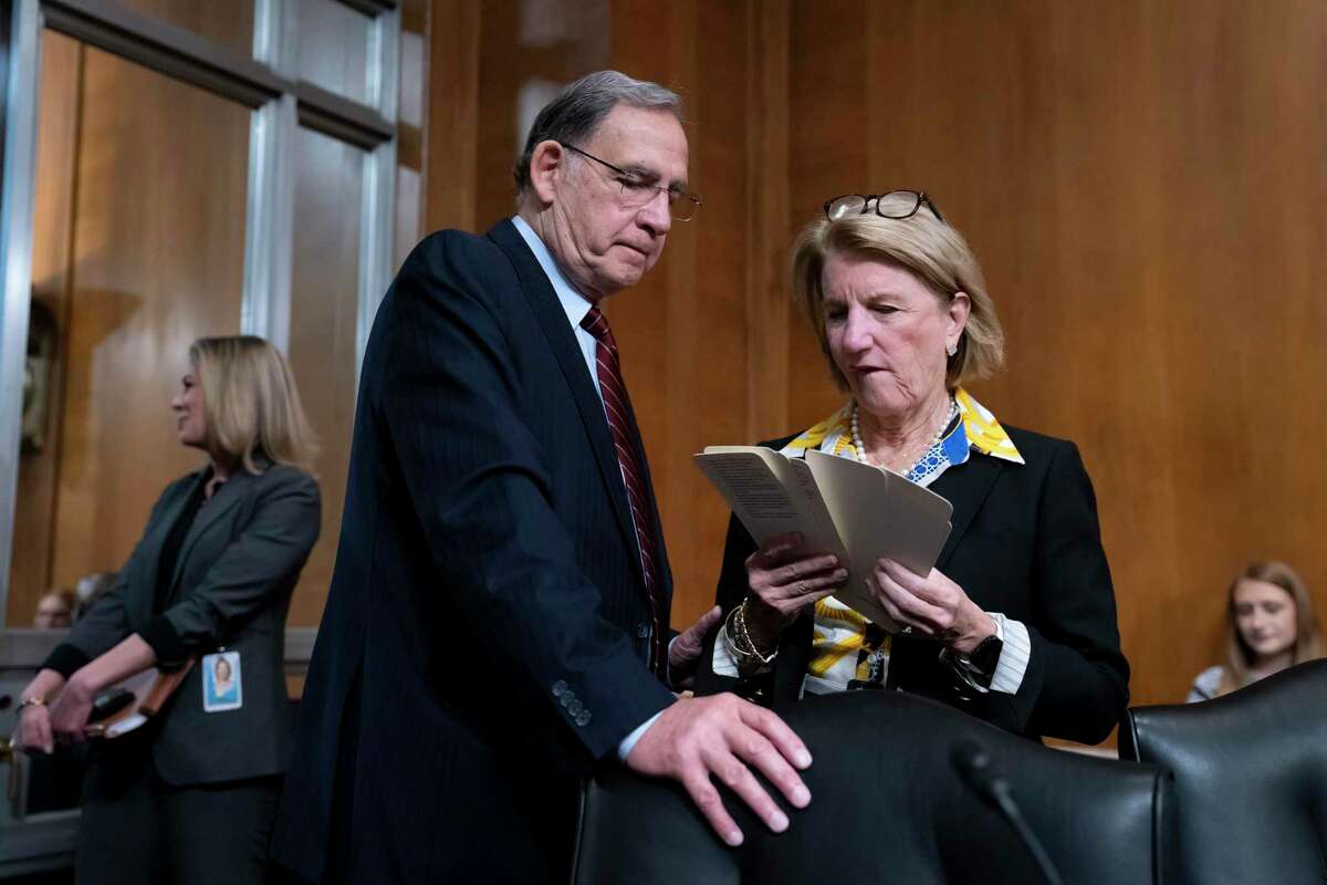 Sen. John Boozman, R-Ark., left, confers with Sen. Shelley Moore Capito, R-W.Va., the ranking member of the Senate Committee on Environment and Public Works, at the start of a business meeting to advance the Water Resources Development Act of 2022, at the Capitol in Washington, Wednesday, May 4, 2022. (AP Photo/J. Scott Applewhite)