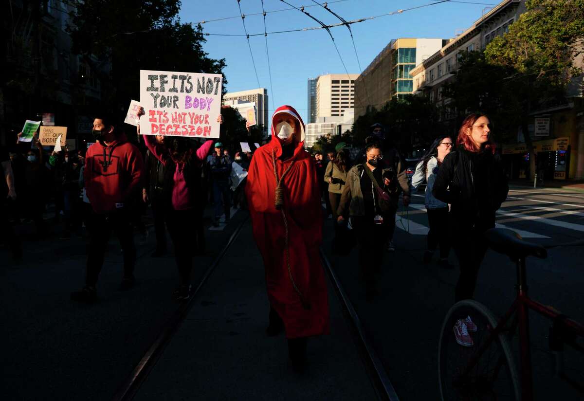 一项调查显示，加州人对罗伊诉韦德案的看法。61岁的帕梅拉·史密斯(Pamela Smith)来自旧金山，她站在旧金山菲利普·伯顿联邦大楼外，抗议最高法院推翻罗伊诉韦德案的决定。