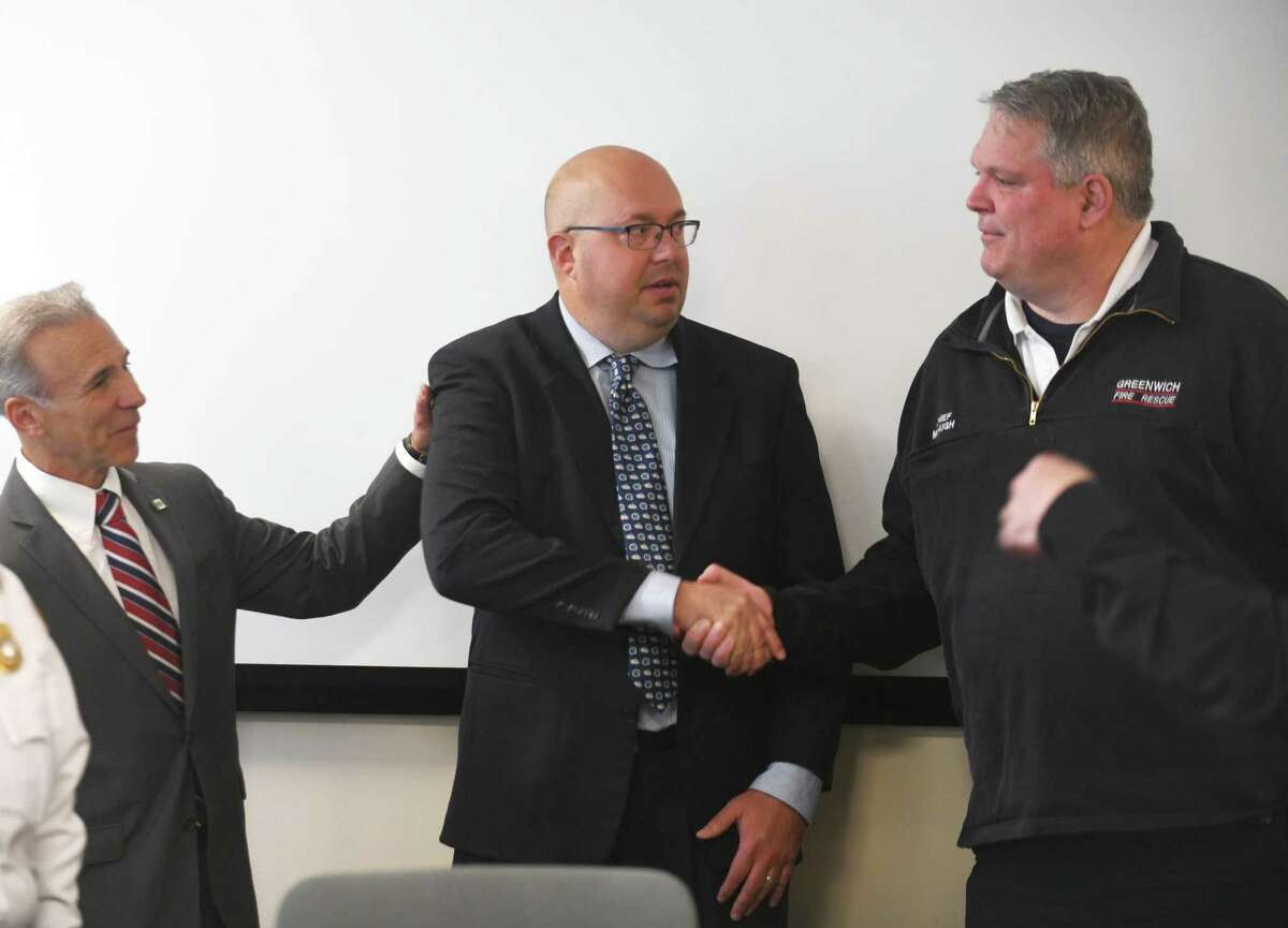 Joseph Laucella, center, is welcomed as the next Emergency Management Director by First Selectman Fred Camillo, left, and Fire Chief Joseph McHugh at the Public Safety Complex's Emergency Operations Center in Greenwich, Conn. Wednesday, May 4, 2022. Laucella, with more than two decades of public safety experience, fills the vacancy created last year by the death of longtime Emergency Management Operations Director Dan Warzoha.