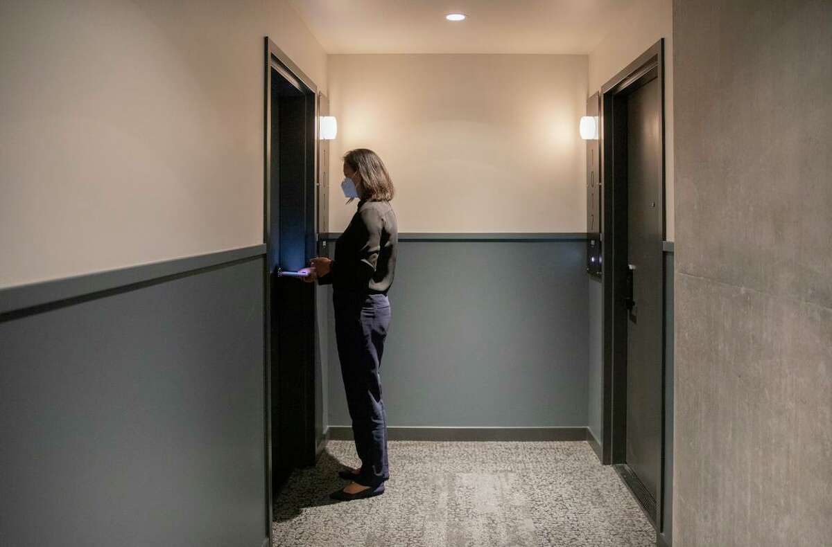 Christie Donnelly opens the door to a unit inside the George Apartments in San Francisco.