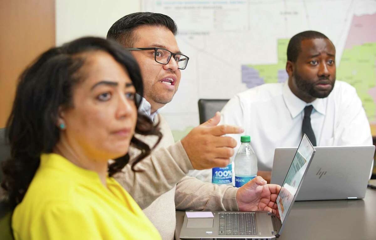 Adrian Acosta, an officer in Academic Instructional Technology at HISD, (center), talks about a new portal that will show how the district is using federal covid relief money at their offices in Houston on Tuesday, May 3, 2022. The portal will be available for the public to see how the district and each individual school is spending the money.