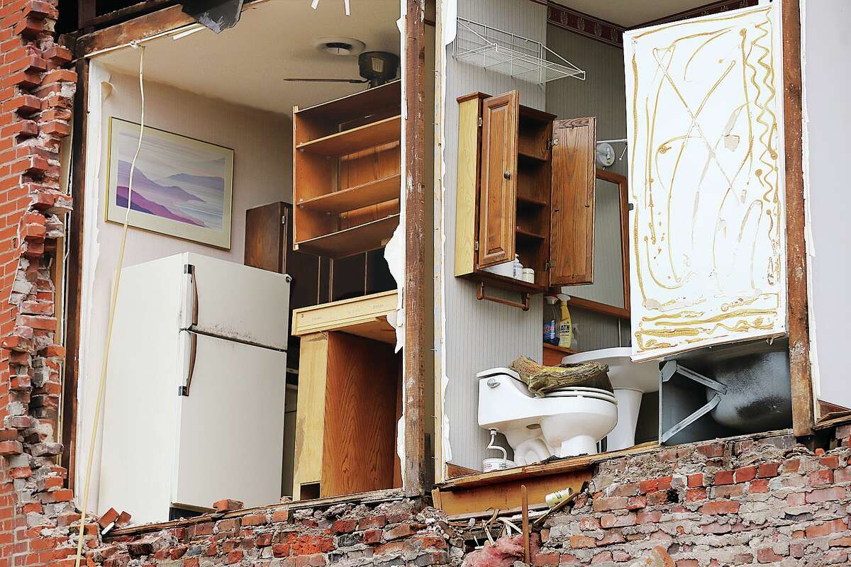 John Badman|The Telegraph A close up look reveals one wall collapsed on an upstairs apartment, exposing a kitchen and restroom.