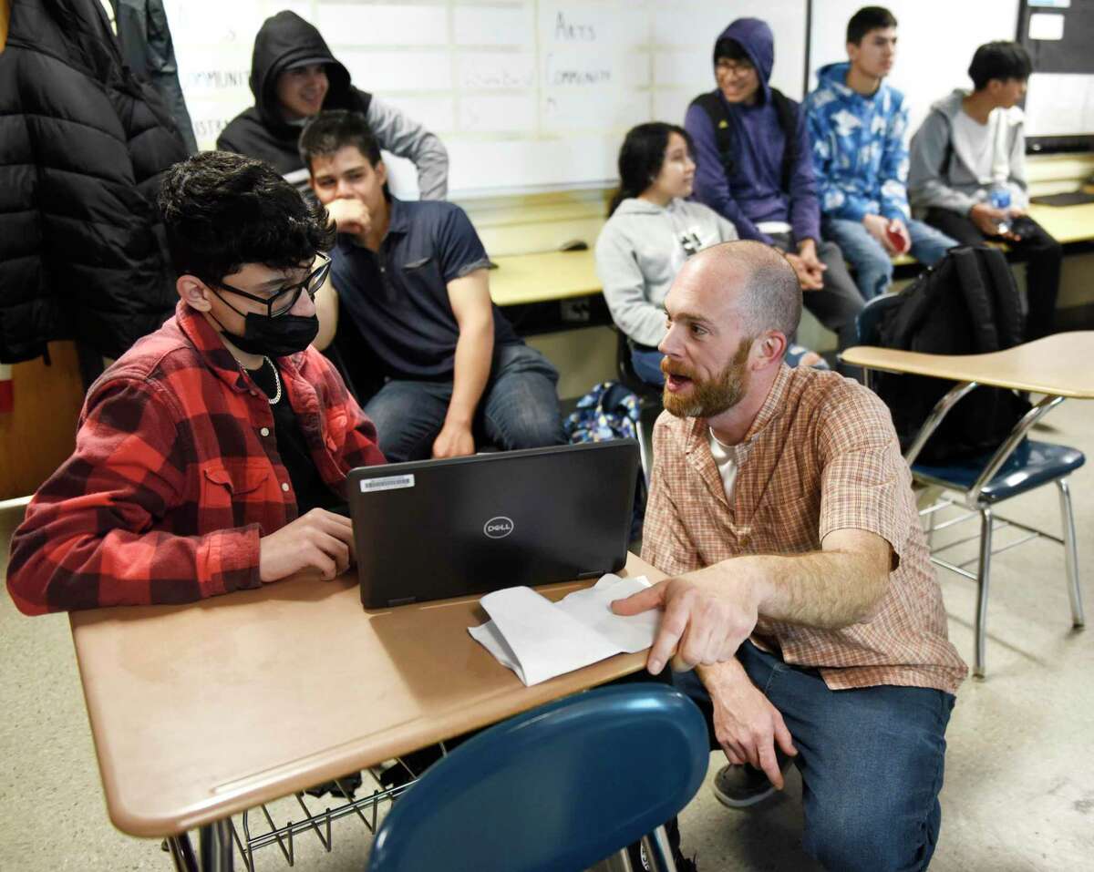 English and journalism teacher Jon Ringel assists sophomore Orislan Lacerda with a project in class at Stamford High School in Stamford, Conn. Wednesday, May 4, 2022. Ringel won this year's Stamford Public Schools Teacher of the Year Award.