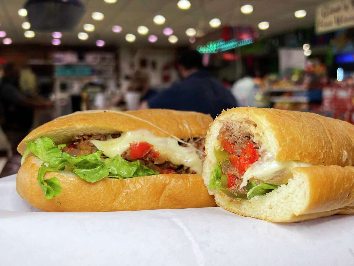 A Philly cheesesteak sandwich comes with sliced rib-eye, provolone cheese, lettuce, tomatoes, jalapeños and grilled onions and peppers at Gino’s Deli, a sandwich shop that’s part of the Stop N Buy convenience store on the North Side.