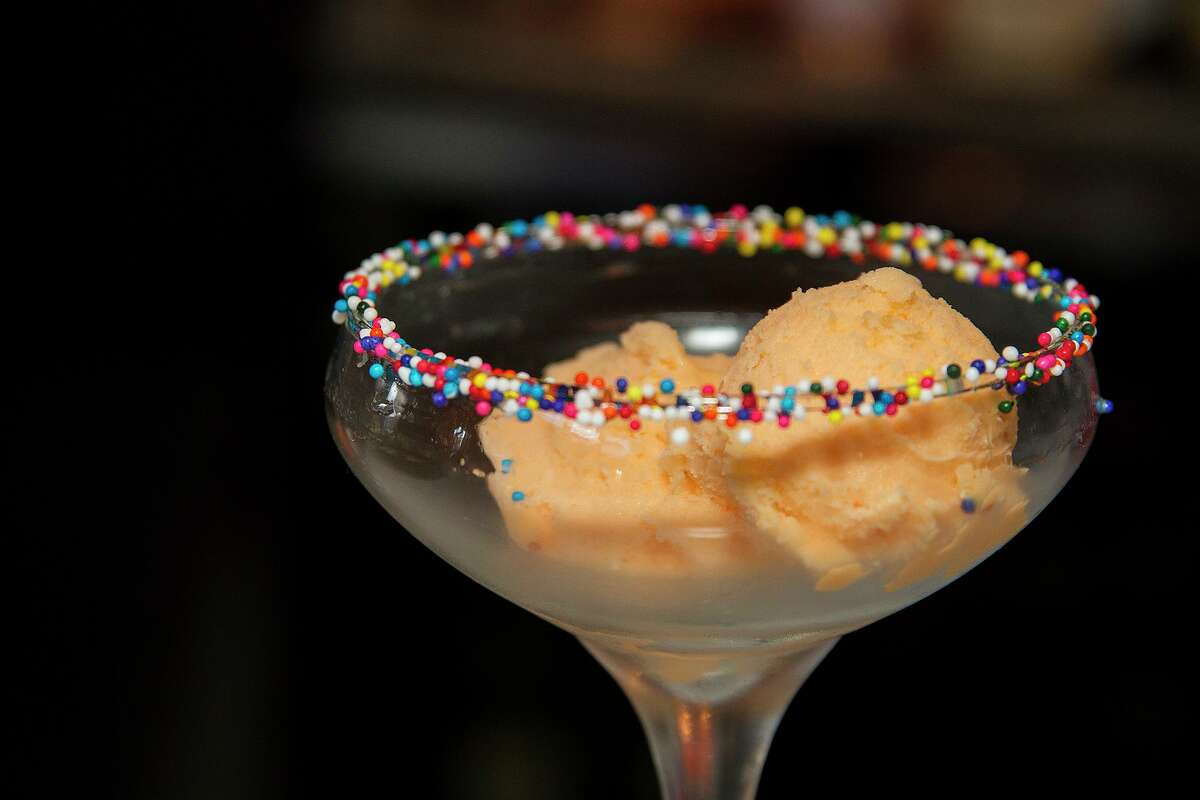 Orange sherbert in a sprinkles rimmed glass is part of the chasing rainbows cocktail at Bite.