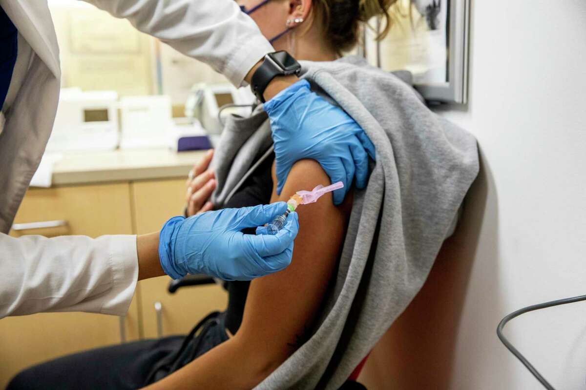 COVID is on track to become as common as the flu. But experts stress that COVID is still, and may always be, no ordinary flu. Elizabeth Worthington, 20, of San Francisco, receives a flu vaccine administered by Nurse Practitioner Diana Huang at a CVS clinic in San Francisco, California Thursday, Sept. 9, 2021.