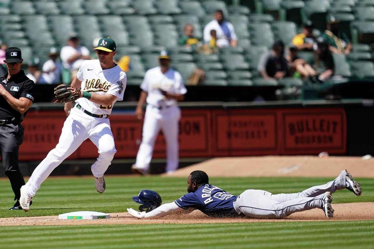 Tampa Bay Rays' Randy Arozarena, bottom, steals third base against Oakland Athletics third baseman Sheldon Neuse during the sixth inning of a baseball game in Oakland, Calif., Wednesday, May 4, 2022. (AP Photo/Jeff Chiu)