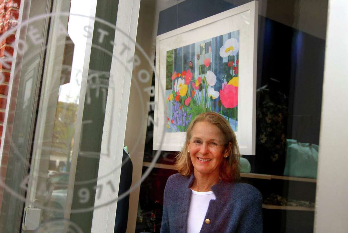 Artist Darrell Lorentzen poses with her artwork hanging in the window at Vilebrequinl during the first day of Art to the Avenue in downtown Greenwich on May 6, 2021. Art to the Avenue returns Thursday night with a kickoff event, and the art will be on display through May 31.