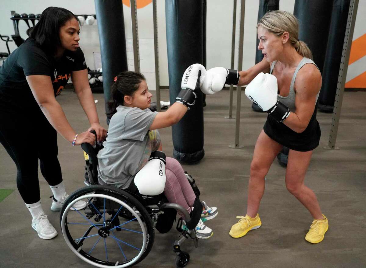 Danielle Henley, personal trainer, left, with Elena Porras, 15, and her mother, Juliet Porras, during a workout at City Centre Life Time, 815 Town and Country Blvd., Tuesday, April 19, 2022, in Houston.