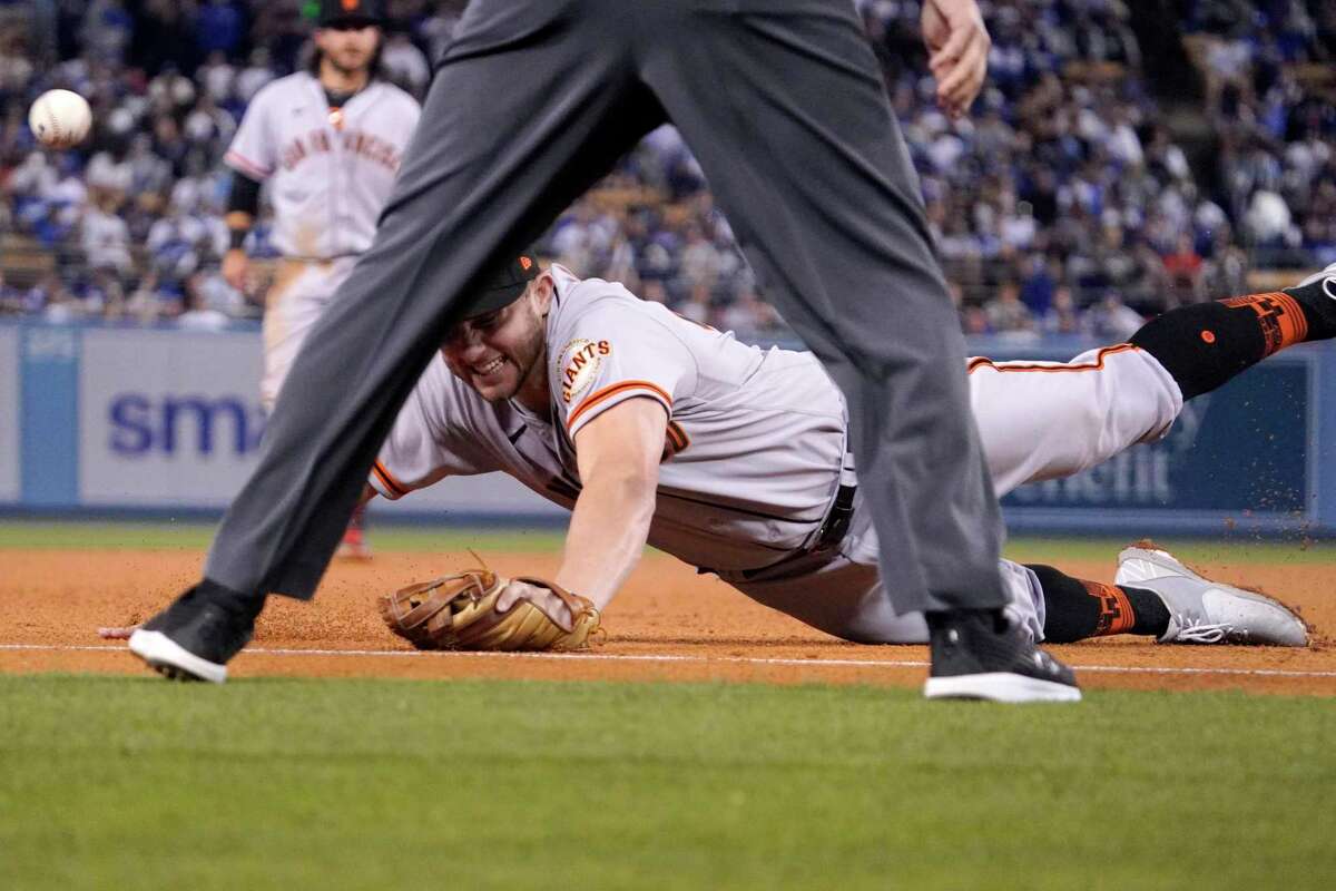 San Francisco Giants third baseman Kevin Padlo dives for a foul ball hit by Los Angeles Dodgers' Justin Turner during the fourth inning of a baseball game Wednesday, May 4, 2022, in Los Angeles. (AP Photo/Mark J. Terrill)