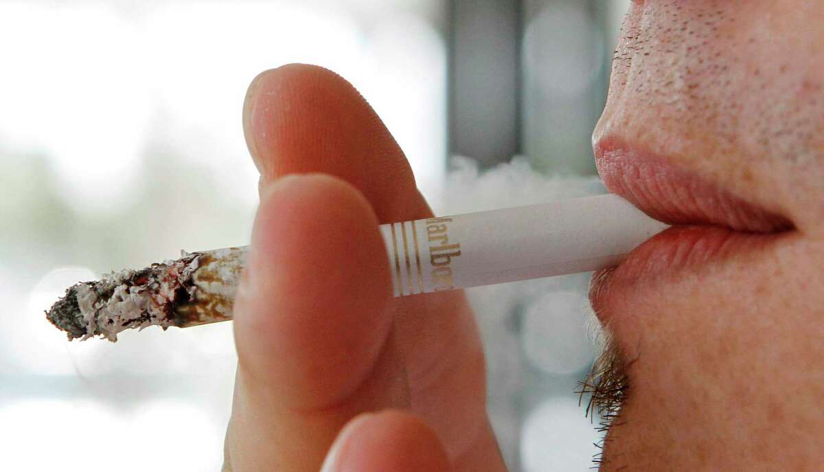 In this Feb. 7, 2011 file photo a person smokes a cigarette in Hialeah, Fla. An updated ordinance on smoking was just approved by the Torrington City Council this week.