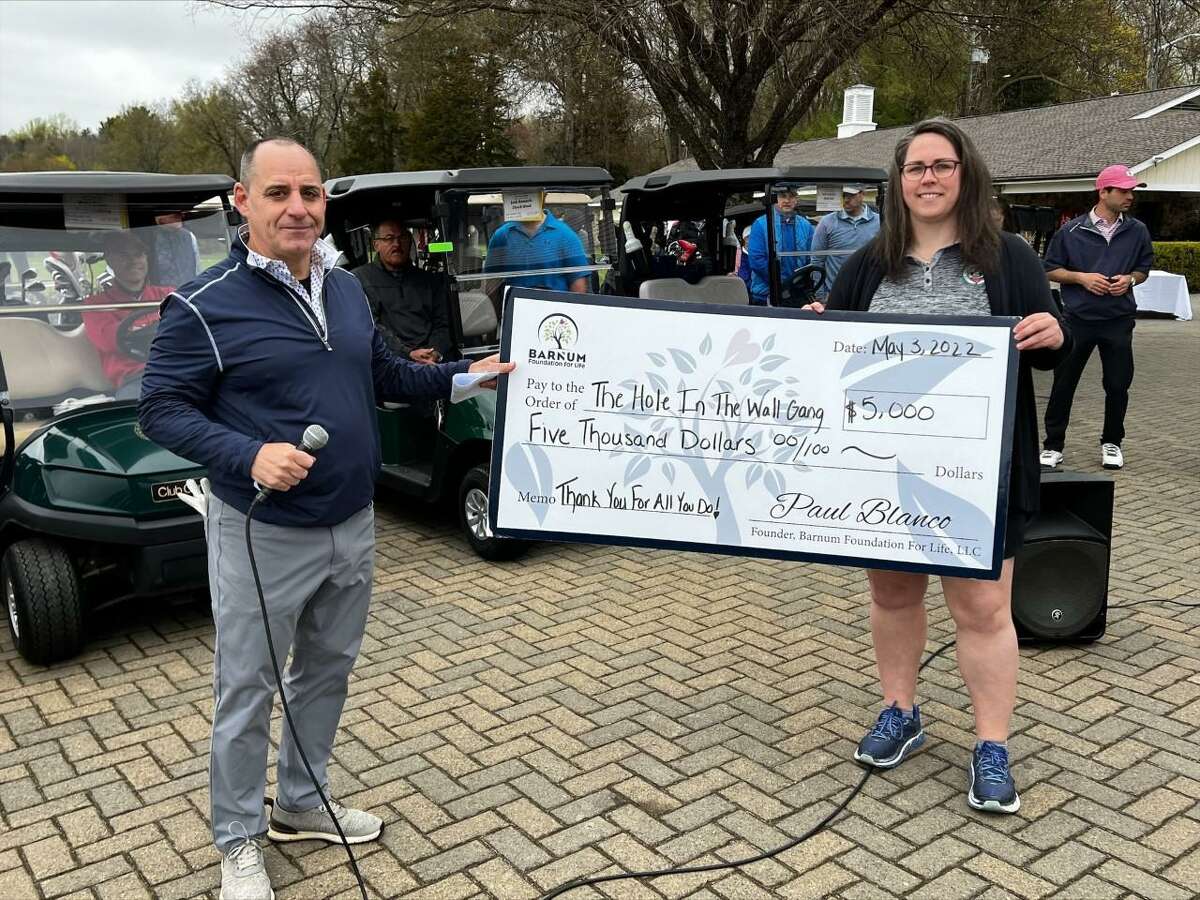 Joe LoPresti, president of the Barnum Foundation for Life, hands a donation check to Andrea Keefe, Director of Community and Corporate Partnerships for The Hole in the Wall Gang Camp.