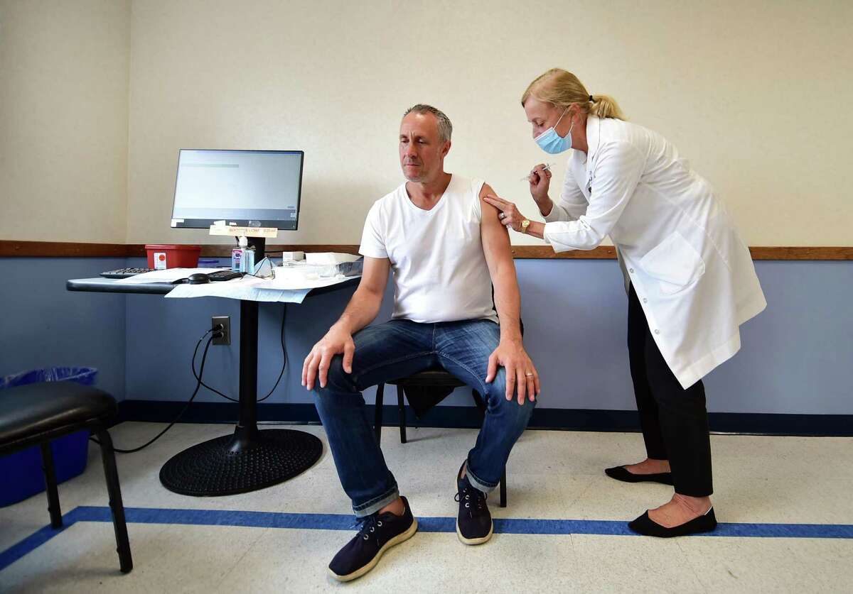 Jeffrey Goldberger gets a booster shot from R.N. Liz Claiborne-Smith during Greenwich Department of Health's Moderna booster clinic, for both first dose and second dose, held at Greenwich Town Hall in Greenwich, Conn., on Wednesday May 4, 2022.