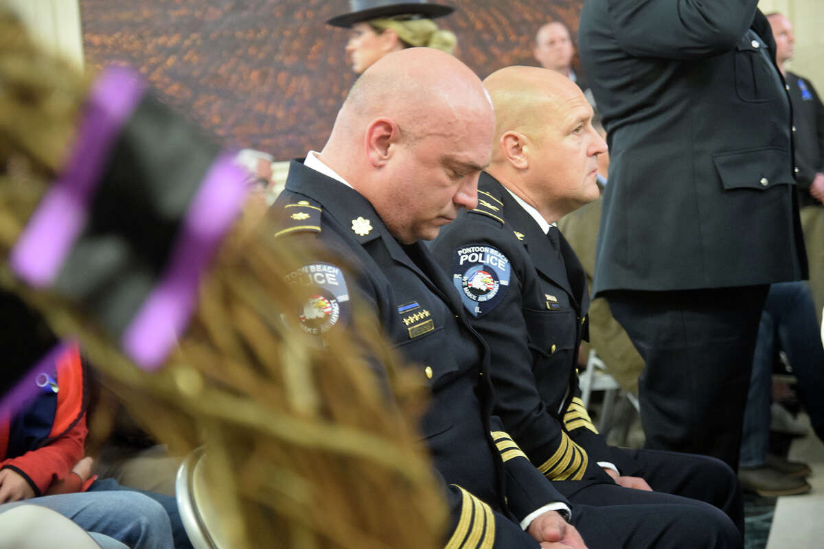 Pontoon Beach Police Officers observe a moment of silence during Thursday's Police Memorial Ceremony in Springfield. In the foreground is a memorial wreath for their late fellow officer Tyler Timmins. 