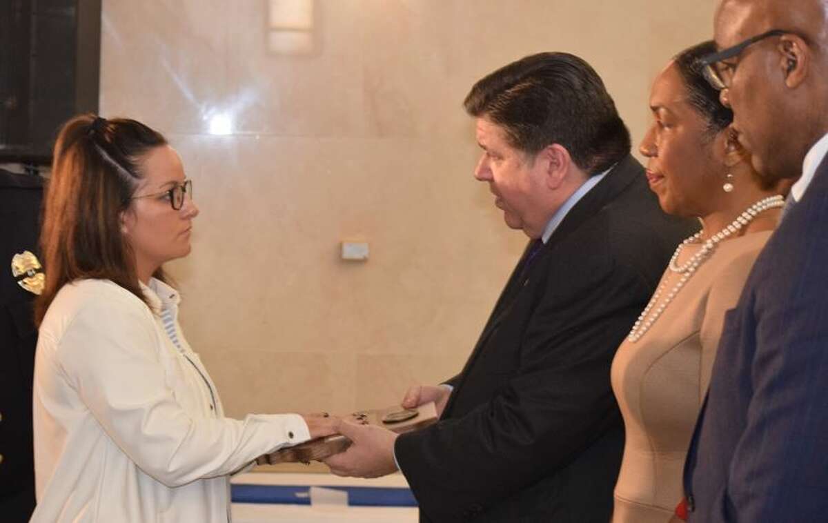 Linsey Timmins, the widow of late Pontoon Beach Police Officer Tyler Timmins, receives a recognition from Gov. J.B. Pritzker during Thursday's Police Memorial Ceremony in Springfield.
