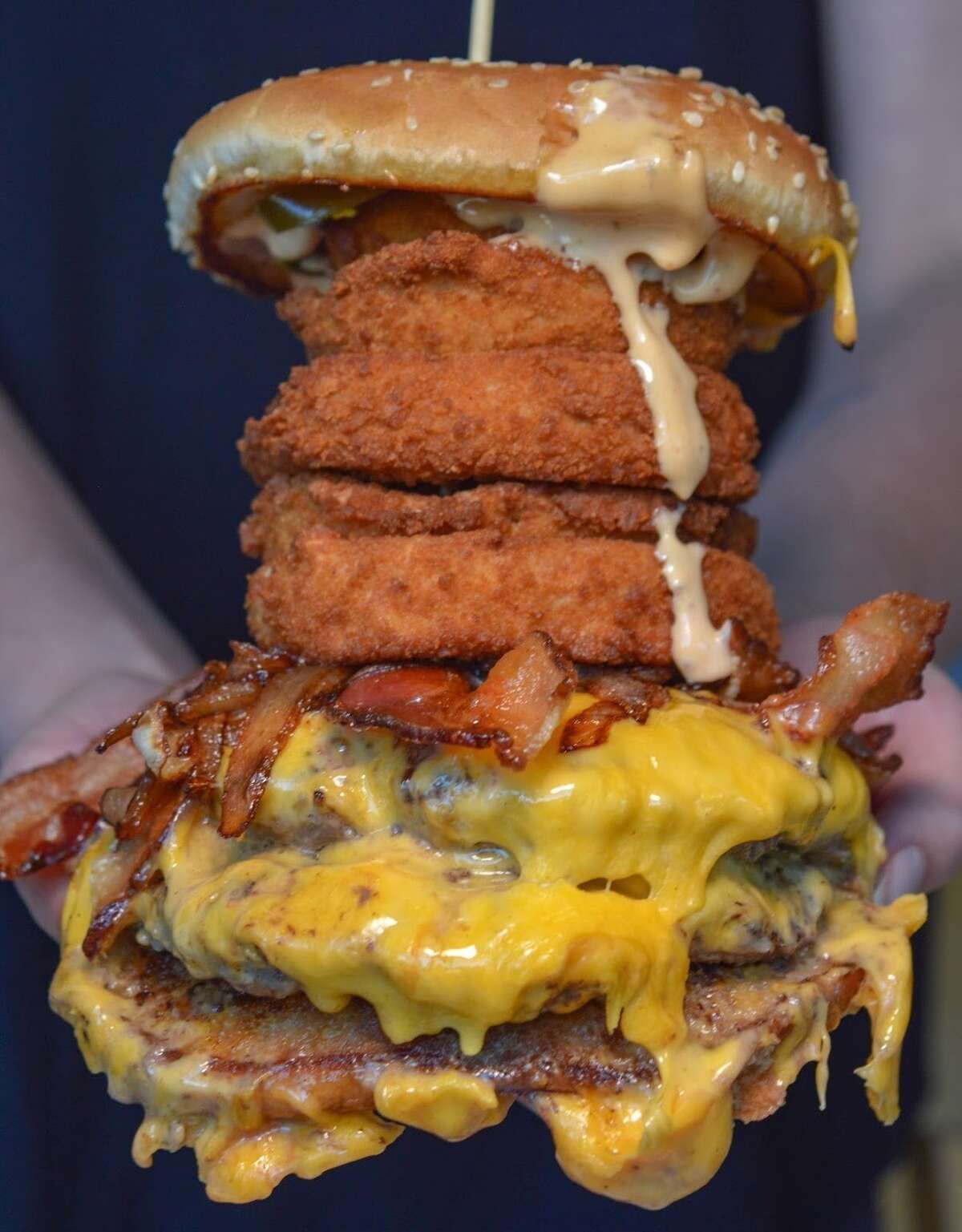 The 5 Rings burger from Elm Street Diner in Stamford, a bacon cheeseburger with caramelized onions, pickles, chipotle aioli and five large housemade onion rings.