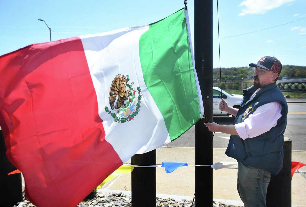 City employee Dan Sexton raises the Mexican flag in celebration of Cinco de Mayo outside City Hall in Derby, Conn., on Thursday, May 5, 2022.